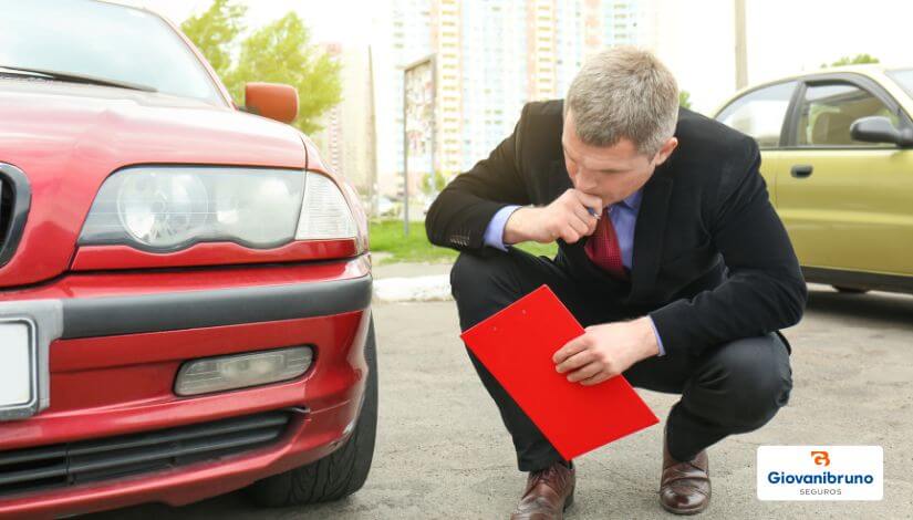 cotação seguro auto - homem avaliando um carro vermelho